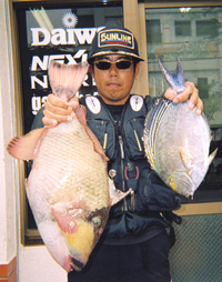 大物モンガラとカワハギを手に喜色満面の砂川力さん(写真提供・海坊)