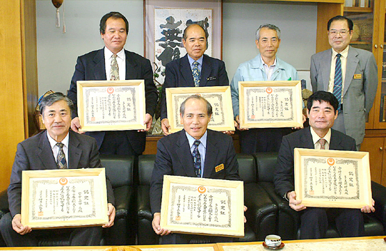 伊良皆助役(前列右)、長浜光雄伊良部総合支所長(同左)に認定証が伝達された=13日、県宮古支庁