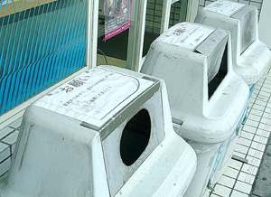 店舗に設置されたごみ箱には、家庭ごみの持ち込みを注意する張り紙がされている=6日、市内のコンビニエンスストア